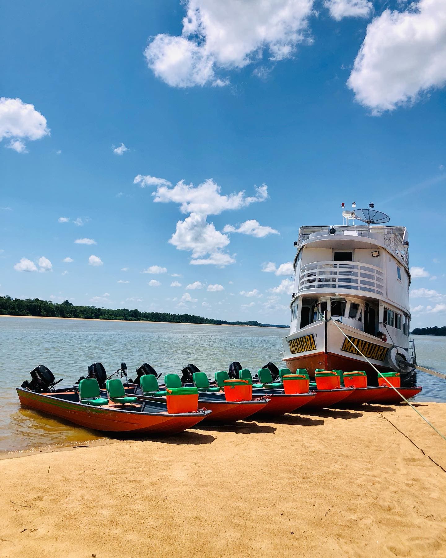 Manauara liveaboard anchored on a Rio Branco beach with the skiff fleet