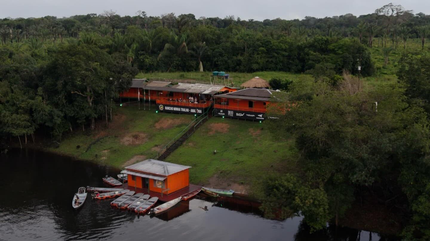 Vista aérea do complexo do Rancho Minha Tralha com flutuante, píer e barcos no Rio Mutuca